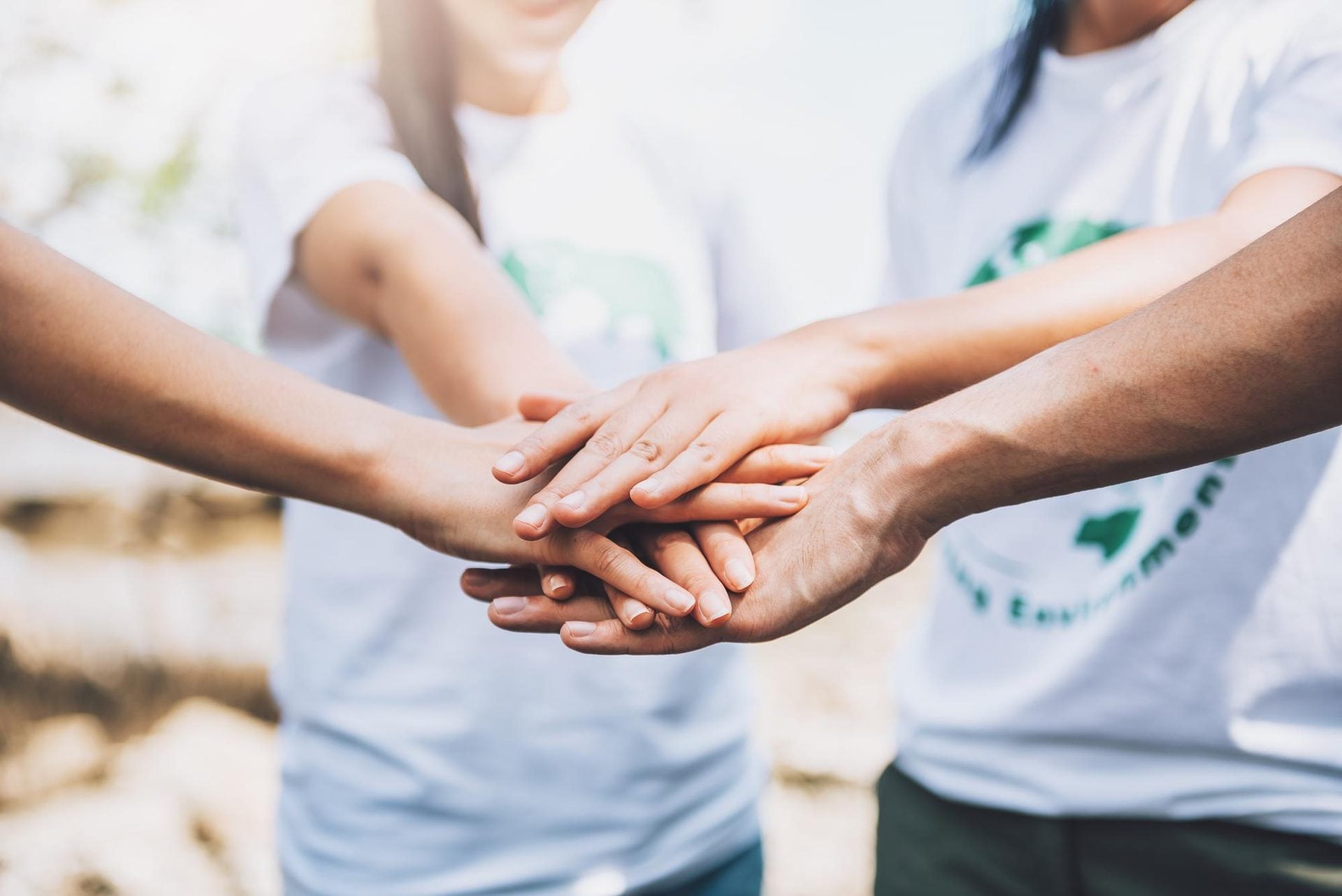Volunteers join hands as a team